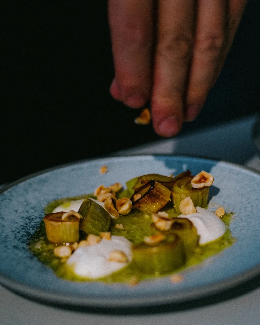 Chef plating food at Faim de Loup in Toronto, photographed by Jasmine Tam