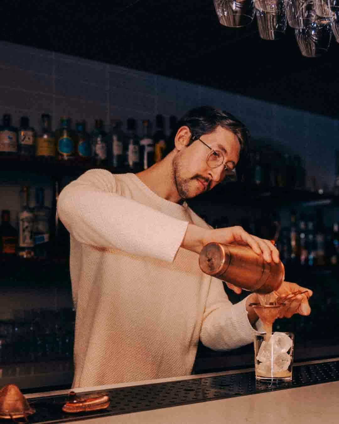 Bartender pouring a cocktail at Sara in Toronto, photographed by Jasmine Tam